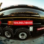 Czarna cysterna drogowa z tablicami ostrzegawczymi dla towarów niebezpiecznych