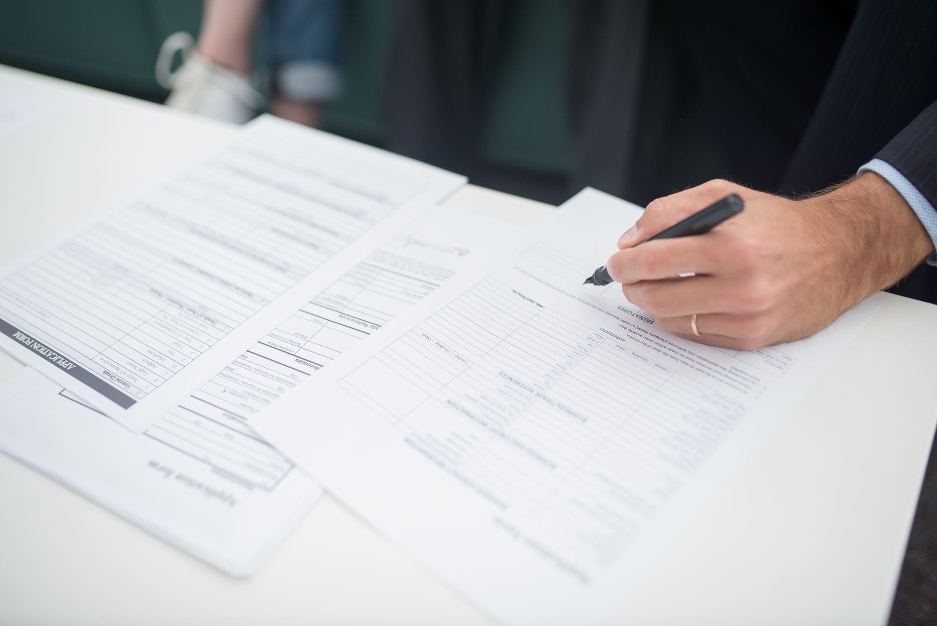 Dłoń podpisująca dokumenty ADR przy biurku w biurze